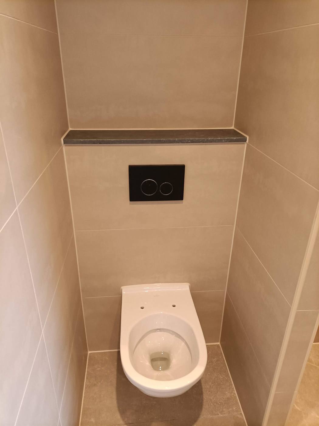 Hangtoilet met inbouwreservoir, strak afgekit tegen de wandtegels