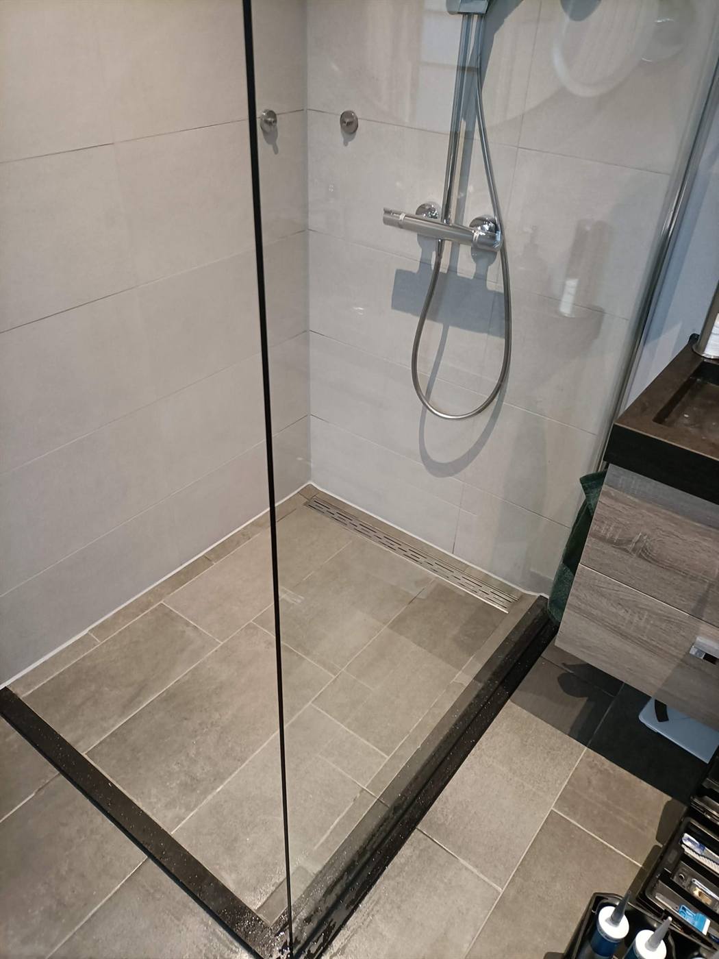 Inloopdouche met glazen wand en douchegoot, waterdicht afgekit